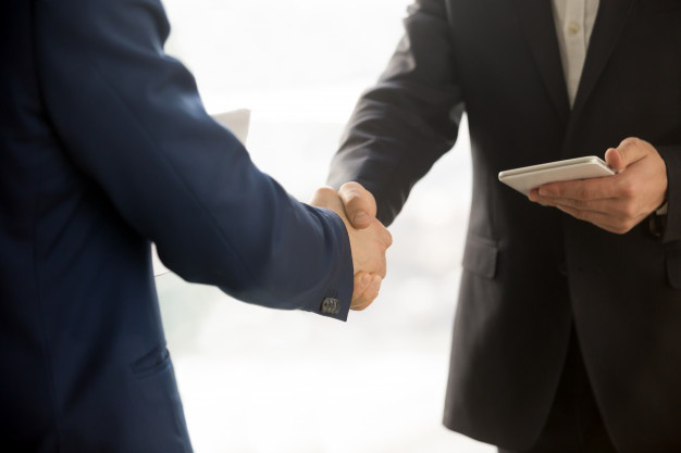 businessmen shaking hands after a deal has been finalized using an electronic chop